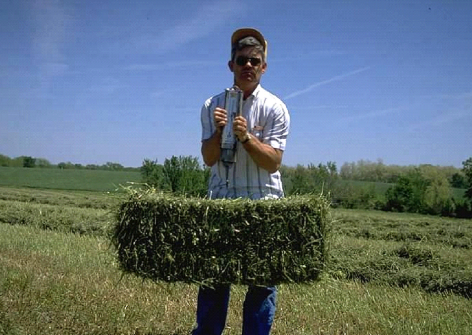 person weighing a square bale